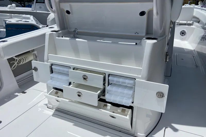 Slide: The Image of 2026 Sportsman Open 322 Center Console with open storage compartments and tackle boxes. - 14