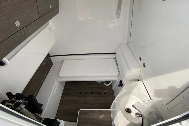 Slide: The Image of Interior of 2026 Sportsman Open 322 Center Console boat, featuring compact bathroom amenities. - 36