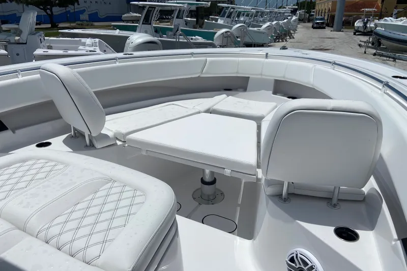Slide: The Image of 2026 Sportsman Open 322 Center Console boat interior with white seating and table. - 25