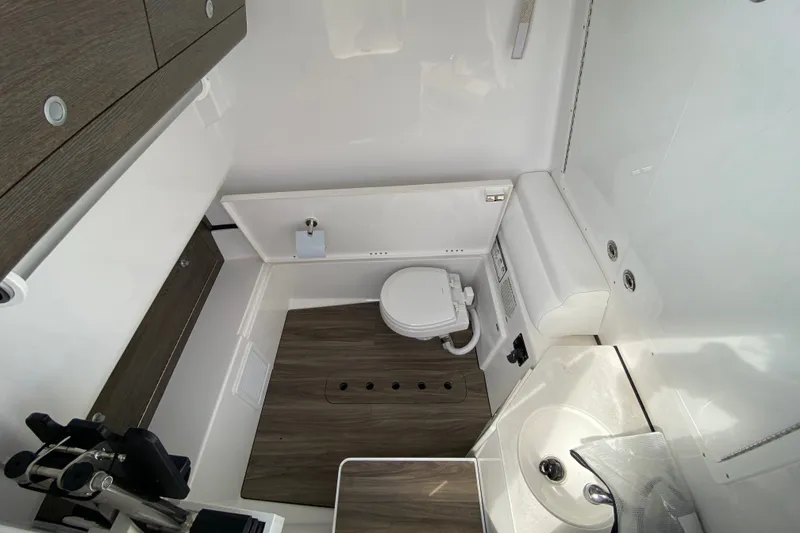 Slide: The Image of Interior view of a modern boat cabin with a toilet, sink, and wood paneling. - 37