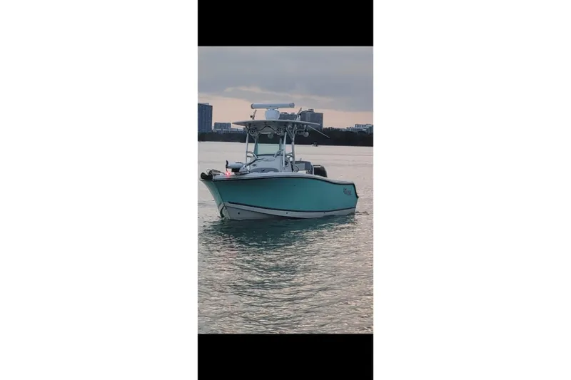Slide: The Image of 2019 Mako 234 Center Console boat on calm water at sunset. - 7