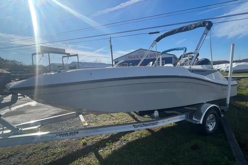 Slide: The Image of 2026 Starcraft SV 18 OB boat on trailer under bright sunlight at a marine center. - 6