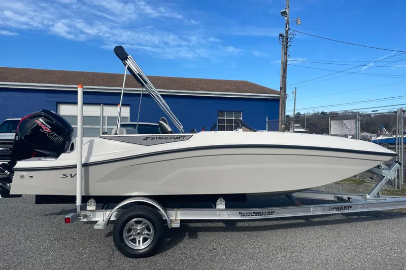 Slide: The Image of 2026 Starcraft SV 18 OB boat on trailer, parked outdoors under blue sky. - 8