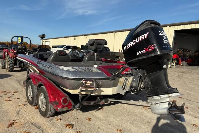 Slide: The Image of 2011 Ranger Z118 Comanche boat with Mercury Pro XS engine in a parking lot. - 2