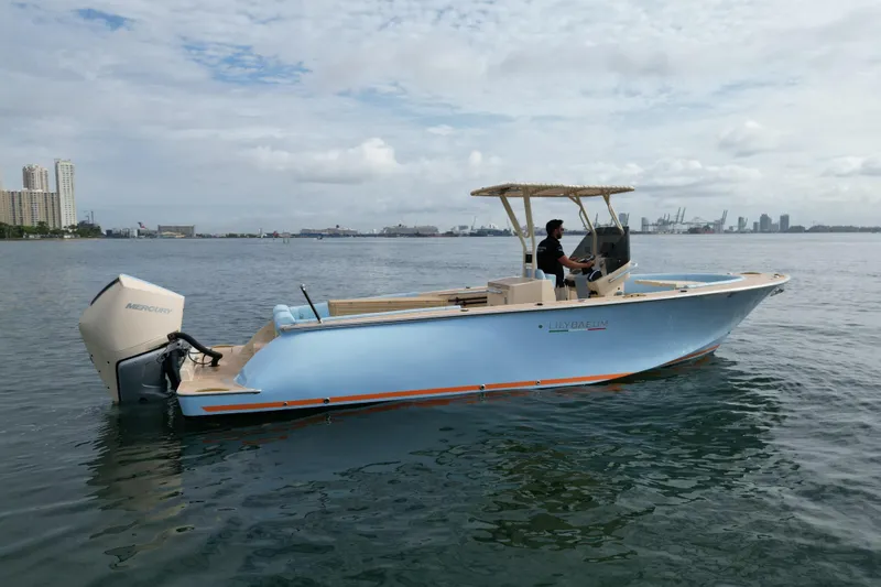 Slide: The Image of 2026 Lilybaeum Levanzo 25 Lounge Deck boat on water, city skyline in background. - 2