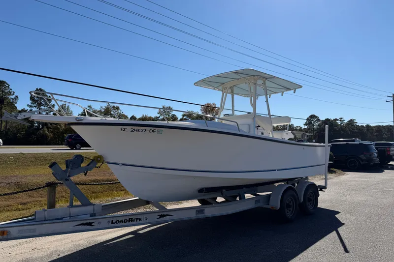 Slide: The Image of 2006 Shamrock 220 Stalker boat on trailer, parked outdoors under clear blue sky. - 2