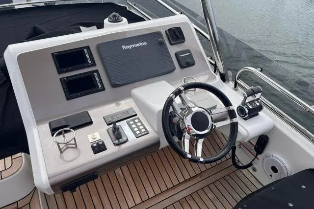 Slide: The Image of Cockpit of 2016 Galeon 660 Flybridge with Raymarine navigation system and wooden deck. - 19