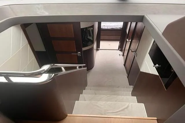 Slide: The Image of Interior staircase of 2016 Galeon 660 Flybridge yacht, featuring modern design and wood accents. - 24