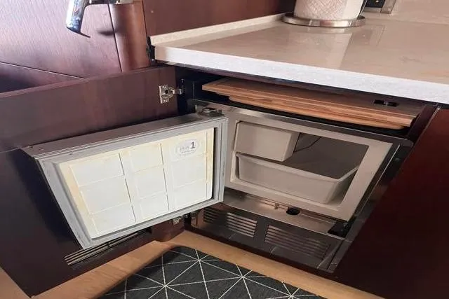 Slide: The Image of Small refrigerator in 2016 Galeon 660 Flybridge yacht kitchen, open with cutting board above. - 29