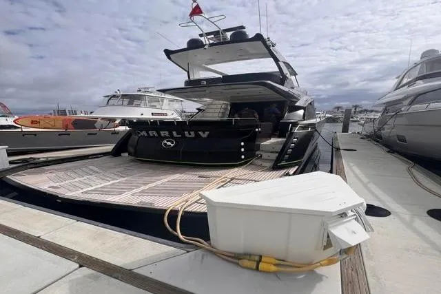 Slide: The Image of Luxury 2016 Galeon 660 Flybridge yacht docked at marina under cloudy sky. - 3
