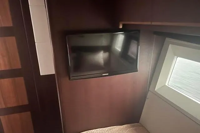 Slide: The Image of Interior of 2016 Galeon 660 Flybridge yacht with wall-mounted TV and window. - 36