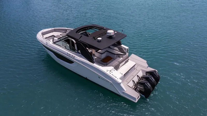 Slide: The Image of 2020 Cruisers Yachts 38 GLS OB on calm blue water, featuring sleek design and triple outboard engines. - 3