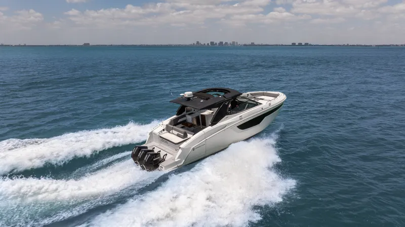 Slide: The Image of 2020 Cruisers Yachts 38 GLS OB speeding on open water under a clear sky. - 11