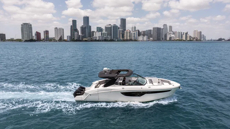 Slide: The Image of 2020 Cruisers Yachts 38 GLS OB cruising on water with city skyline in background. - 14