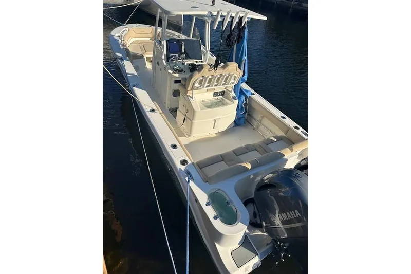 Slide: The Image of 2018 NauticStar 2602 Legacy boat with Yamaha engine, docked on calm water. - 2