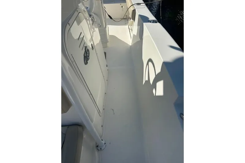 Slide: The Image of 2018 NauticStar 2602 Legacy boat interior, showcasing clean white deck and seating area. - 22