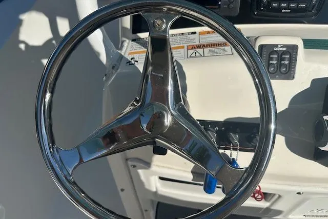 Slide: The Image of Steering wheel of 2018 NauticStar 2602 Legacy boat, featuring control panel and warning labels. - 25