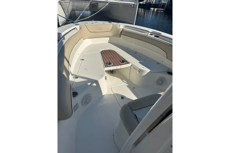Slide: The Image of 2018 NauticStar 2602 Legacy boat interior with seating and table, docked at marina. - 28