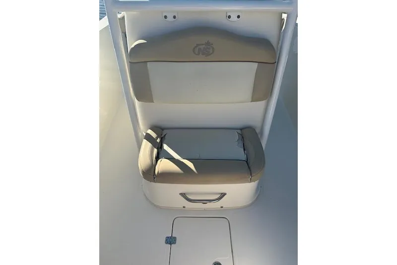 Slide: The Image of 2018 NauticStar 2602 Legacy boat seat with beige cushions and storage compartment. - 42