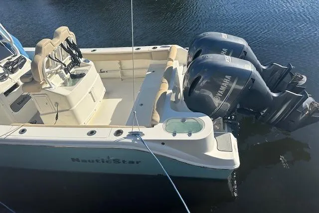 Slide: The Image of 2018 NauticStar 2602 Legacy boat with dual Yamaha engines on calm water. - 7