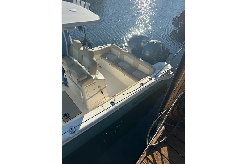 Slide: The Image of 2018 NauticStar 2602 Legacy boat docked, featuring dual outboard motors. - 9