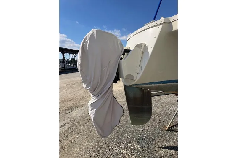 Slide: The Image of 1981 Witness Catamaran with outboard motor on gravel surface. - 10