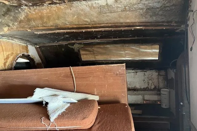 Slide: The Image of Interior view of a 1981 Witness Catamaran, showing storage compartment and rigging components. - 16