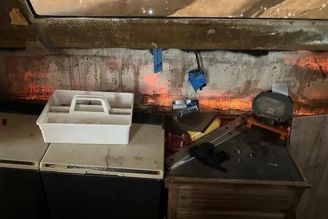 Slide: The Image of 1981 Witness Catamaran mast on stands in a boatyard under a partly cloudy sky. - 17