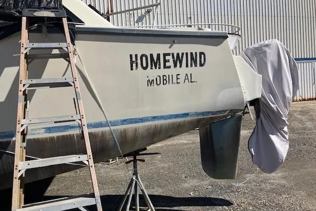 Slide: The Image of 1981 Witness Catamaran with covered outboard motor and visible propeller on dry dock. - 7
