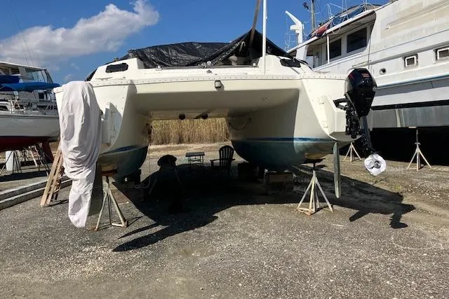 Slide: The Image of 1981 Witness Catamaran on dry dock, supported by stands, with clear blue sky. - 8