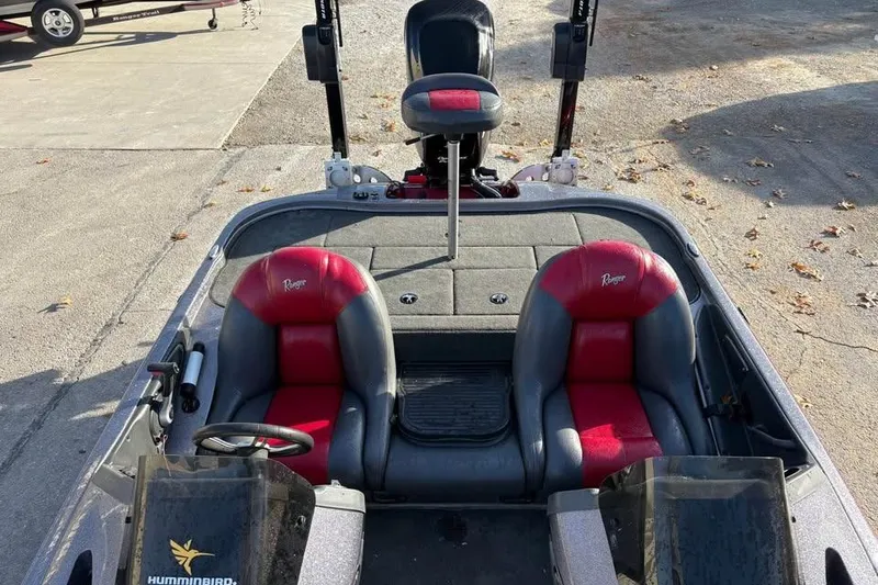 Slide: The Image of 2011 Ranger Z118 Comanche boat interior with red and gray seats, steering wheel, and equipment. - 11