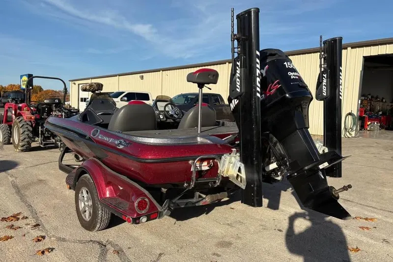 Slide: The Image of 2011 Ranger Z118 Comanche boat with motor and trailer parked outdoors. - 2