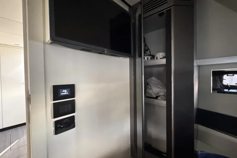 Slide: The Image of 2023 Azimut Verve 47 interior with TV, control panels, and storage shelves. - 94