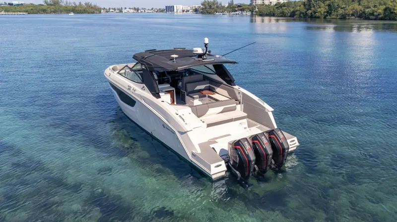 Slide: The Image of 2021 Cruisers Yachts 38 GLS OB 450R on clear water, showcasing triple outboard engines. - 2
