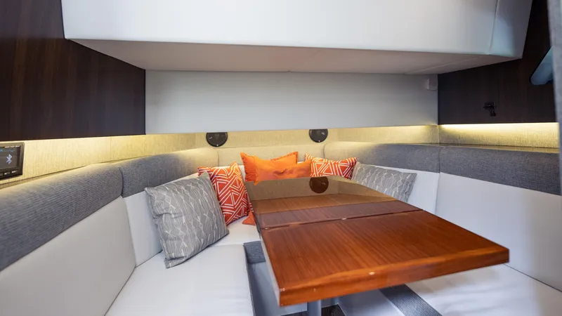 Slide: The Image of Interior of 2021 Cruisers Yachts 38 GLS OB 450R with cozy seating and wooden table. - 32