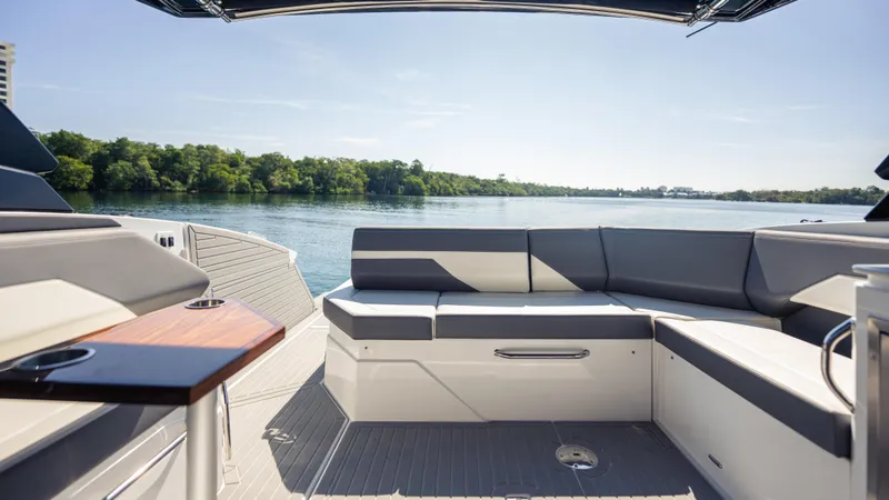 Slide: The Image of Luxurious seating area on 2021 Cruisers Yachts 38 GLS OB 450R, overlooking serene water and lush greenery. - 34