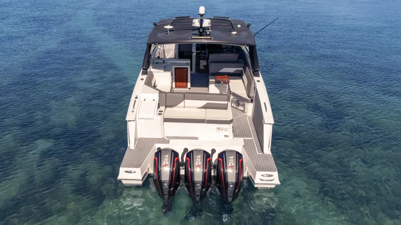 Slide: The Image of 2021 Cruisers Yachts 38 GLS OB 450R on clear water, rear view with triple engines. - 10