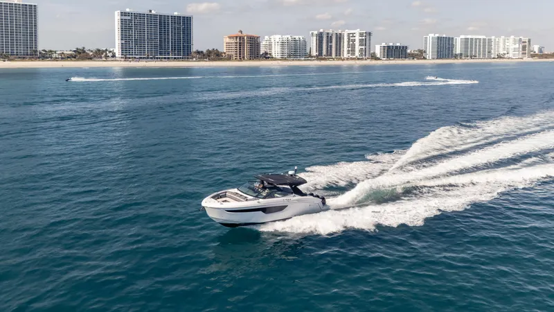 Slide: The Image of 2021 Cruisers Yachts 38 GLS OB 450R speeding on ocean near city skyline. - 23