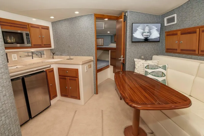Slide: The Image of 2008 Cabo Yachts 38 EXPRESS interior with kitchenette, dining area, and cozy sleeping quarters. - 10
