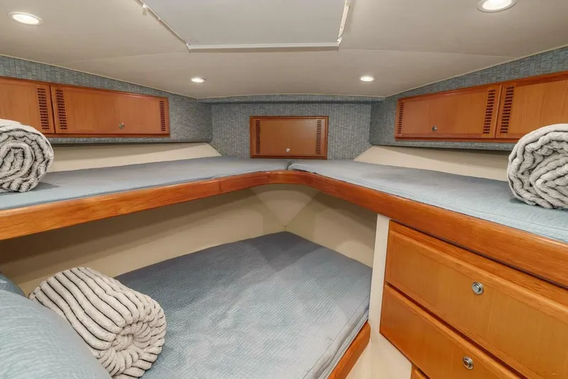 Slide: The Image of 2008 Cabo Yachts 38 EXPRESS cabin with cozy bedding and wooden storage cabinets. - 11