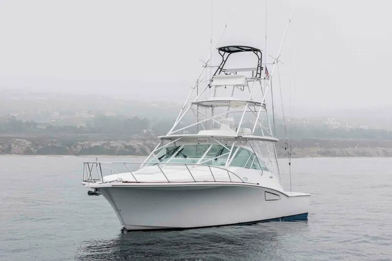 Slide: The Image of 2008 Cabo Yachts 38 EXPRESS on calm waters with misty shoreline background. - 26
