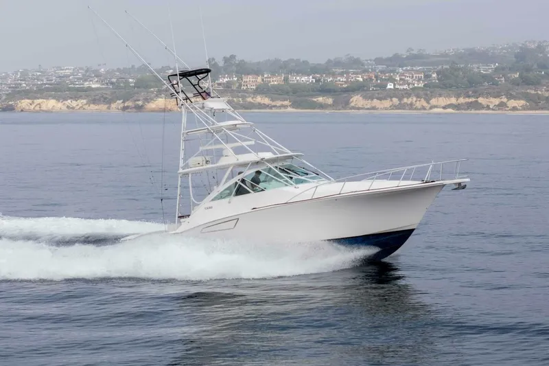 Slide: The Image of 2008 Cabo Yachts 38 EXPRESS cruising on calm waters near a scenic coastline. - 39