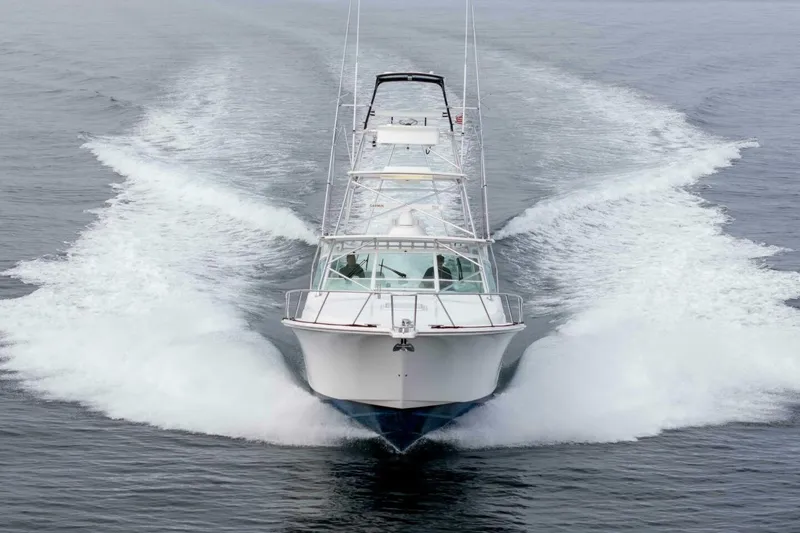 Slide: The Image of 2008 Cabo Yachts 38 EXPRESS cruising on open water, creating a dynamic wake. - 40