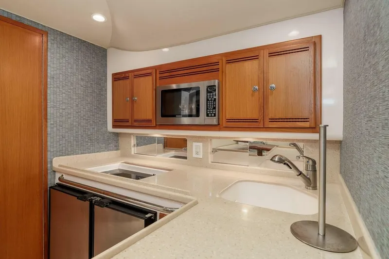 Slide: The Image of 2008 Cabo Yachts 38 EXPRESS kitchen with microwave, sink, and wooden cabinets. - 8