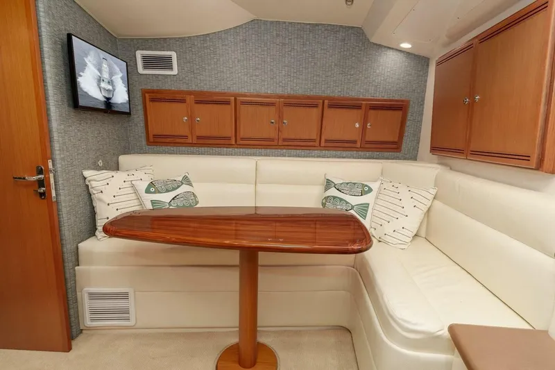 Slide: The Image of 2008 Cabo Yachts 38 EXPRESS interior with white seating, wooden table, and wall cabinets. - 9