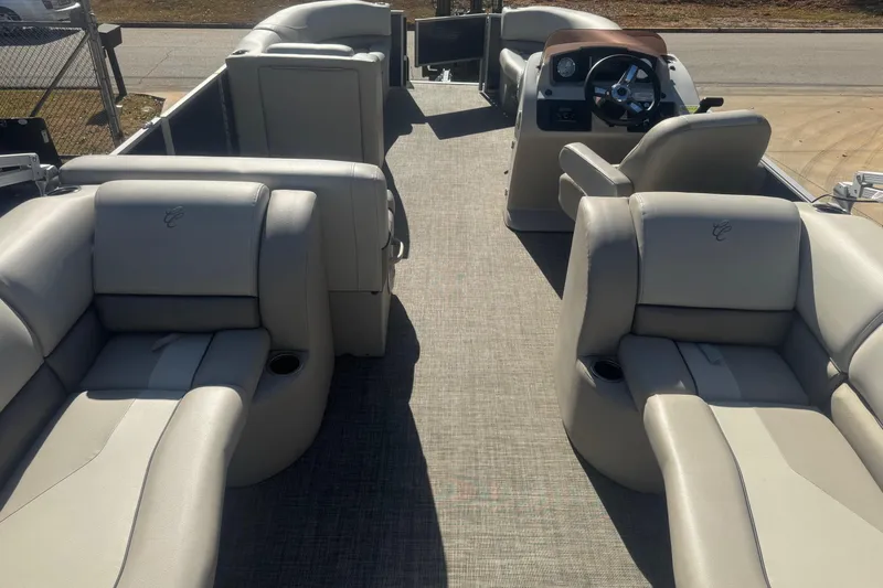 Slide: The Image of 2023 Cypress Cay Seabreeze 232 pontoon boat interior with plush seating and steering console. - 3