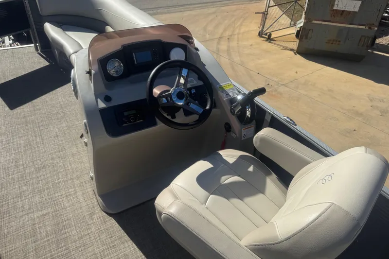 Slide: The Image of 2023 Cypress Cay Seabreeze 232 boat interior with steering wheel and captain's chair. - 7