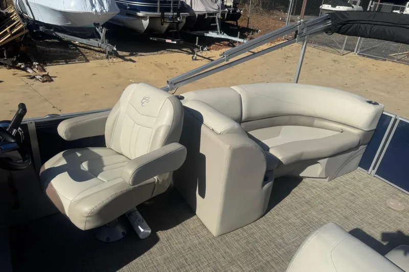 Slide: The Image of 2023 Cypress Cay Seabreeze 232 boat interior with plush seating and steering area. - 8