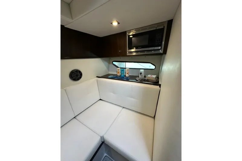 Slide: The Image of Interior of 2021 Cruisers Yachts 338 South Beach Edition, featuring cozy seating and a microwave. - 11