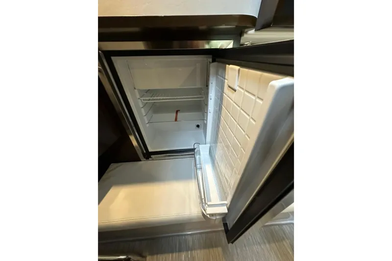 Slide: The Image of Open refrigerator inside 2021 Cruisers Yachts 338 South Beach Edition Bow Rider. - 13